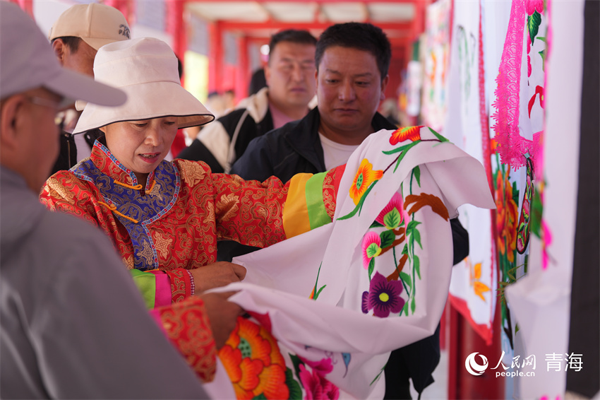 欣賞土族阿姑刺繡作品。人民網(wǎng) 陳明菊攝